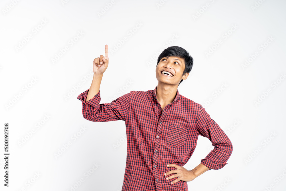 smiling young man with finger pointing up on isolated background smiling young man with finger pointing up on isolated background