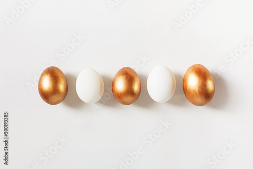 Set of Easter golden color eggs isolated on white background. Stylish trendy frame composition with gold chocolate egg. Flat lay, top view, place for text. Happy egg hunt for kids concept