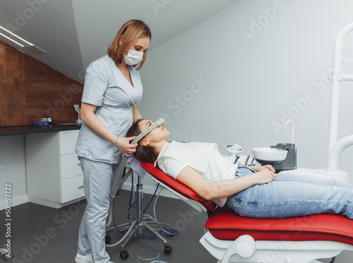 Canvas Print dentist puts inhalation sedative mask on his patient.