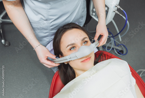 dentist puts inhalation sedative mask on his patient. photo