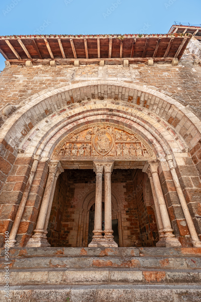 Entrance with doric columns, medieval tympanum of Church Eglise Saint-Pierre de Carennac, showing Christ in Majesty surrounded by four evangelists and apostles. Lot, Occitanie, France