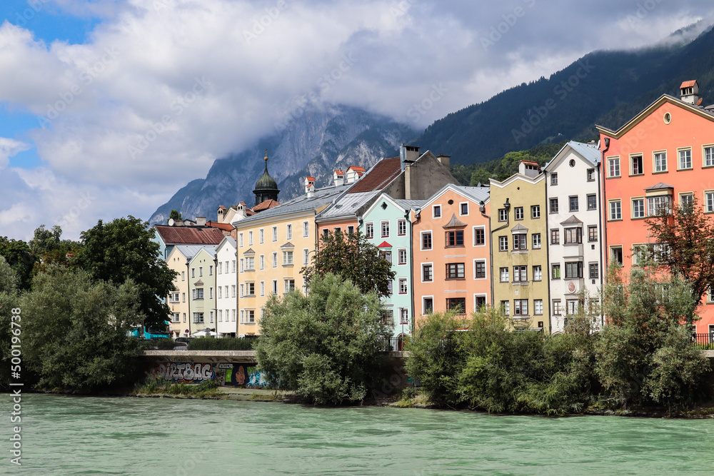 Innsbruck from the Inn River with Colorful Buildings and Mountains during Cloudy Summer Day. Beautiful Architecture of Alpine City in Tyrol.