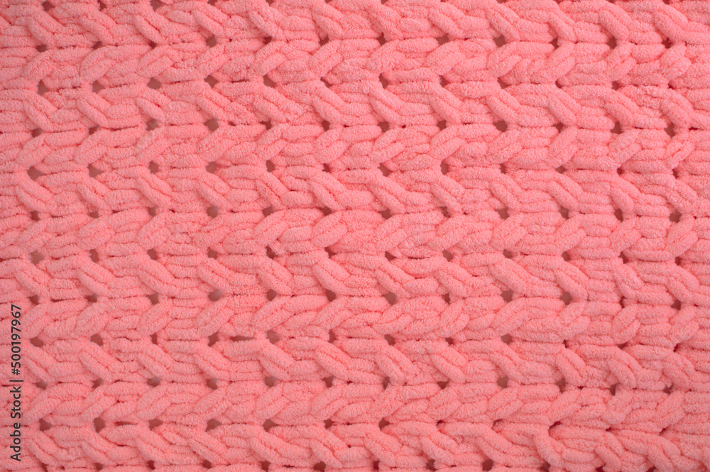 Texture of a pink large knitted blanket. Large knitting. Checkered merino wool. Pink knitted fabric. Space for copying. Flat position, top view. Texture of a pink large knitted blanket. Large knitting. Checkered merino wool. Pink knitted fabric. Space for copying. Flat position, top view.