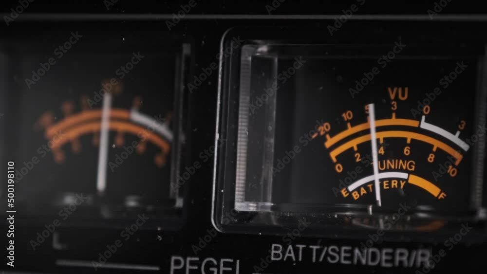 Analog VU meters on black colored stereo tape recorder, arrow