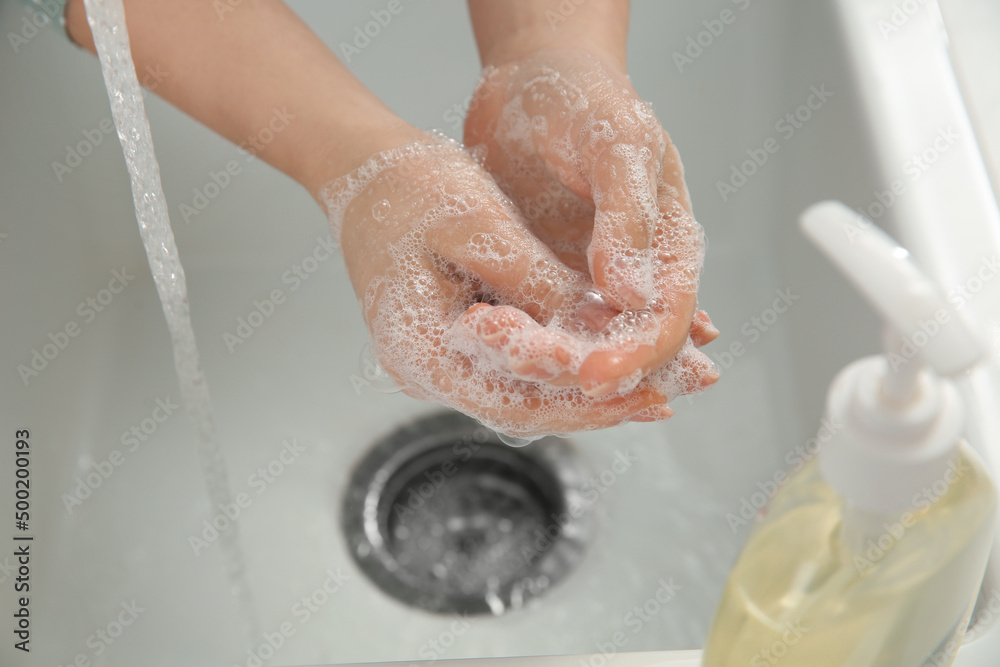 Fototapeta premium Woman washing hands with liquid soap, closeup