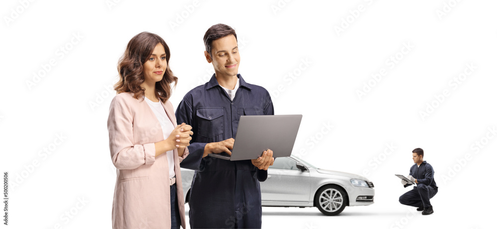 Young woman looking at a laptop computer with a male mechanic worker