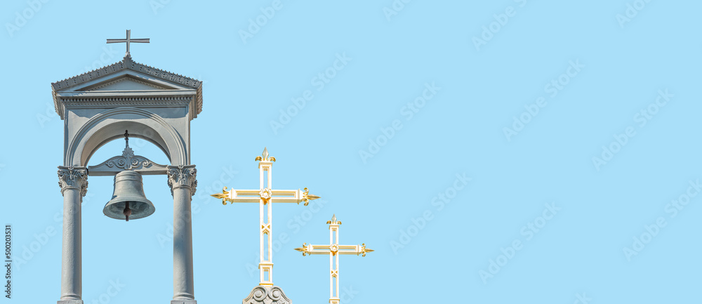 Banner with ancient monastery poor bell tower with rich golden crosses at blue sky solid background with copy space. Concept of religious contrast, inequality.