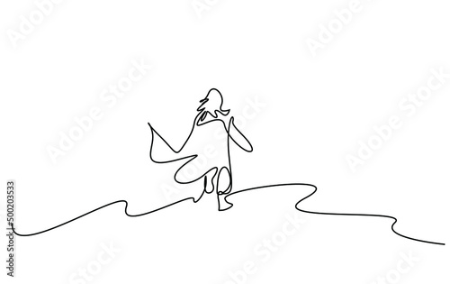 a woman peacefully and happily running alone in nature with her back turned and her dress waving her hair