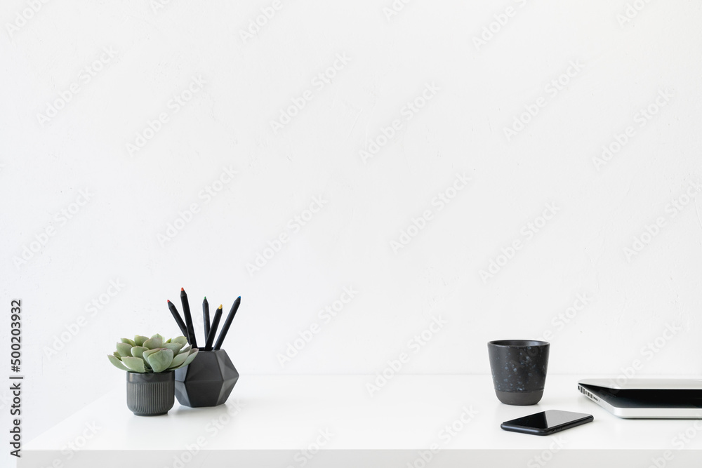 Office table, empty desk with supplies, mobile and white wall copy space.
Office table, empty desk with supplies, mobile and white wall copy space.