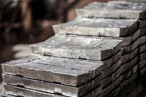 Close-up of a pile of zinc ingots. Raw materials for the smelting industry. Aluminum, tin, iron. Rough metal bricks. photo