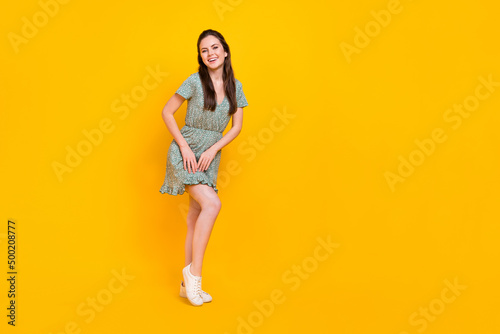 Photo of shiny sweet woman wear print dress dancing empty space isolated yellow color background