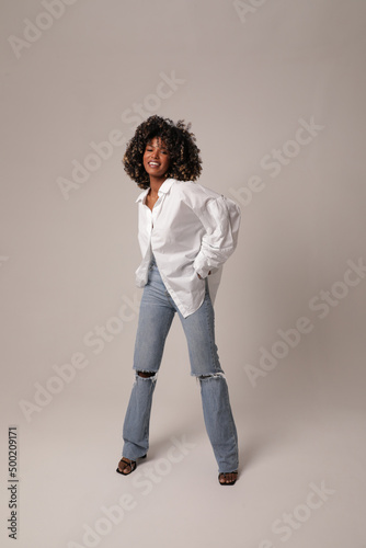 Portrait of beautiful young woman posing in the white studio. Full-length photo.