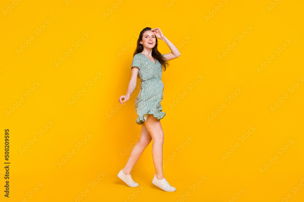 Photo of dreamy excited woman wear print dress dancing running looking empty space isolated yellow color background Photo of dreamy excited woman wear print dress dancing running looking empty space isolated yellow color background