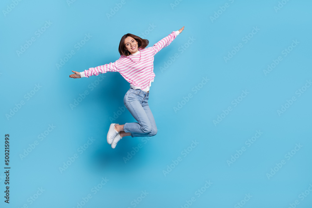 Full size photo of impressed young lady jump wear shirt jeans sneakers isolated on blue background