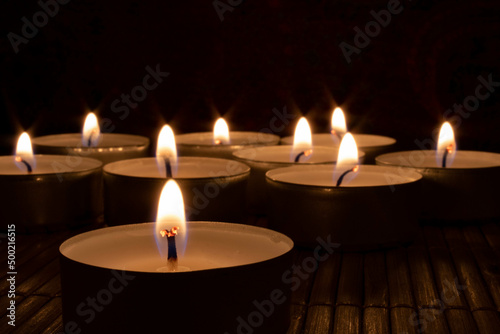 Close-up of lit candles In darkroom. Romance, hope, peace concept