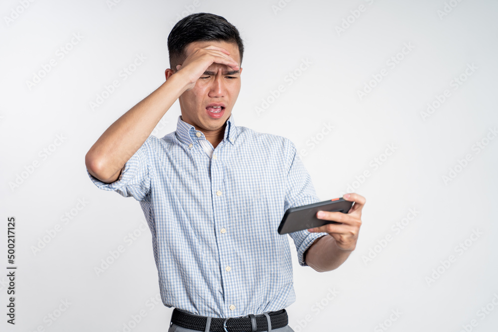 excited young asian man playing video game on his smartphone excited young asian man playing video game on his smartphone