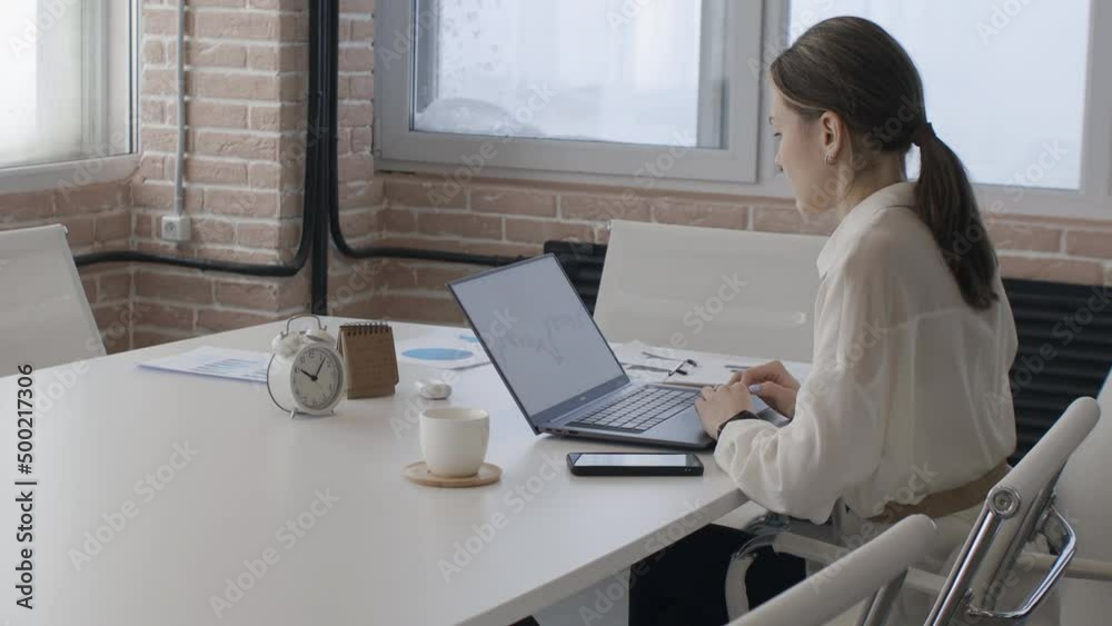 A woman works on a laptop in the office. Remote work and self-development, online learning A woman works on a laptop in the office. Remote work and self-development, online learning