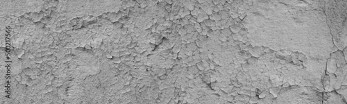 Old cracked grey exterior wall wide panoramic texture. Shabby rough damaged surface. Abstract large long grunge background