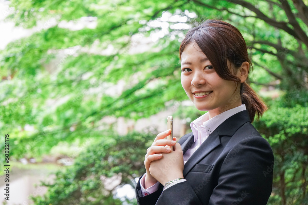 スマホでメッセージを打つビジネスウーマン