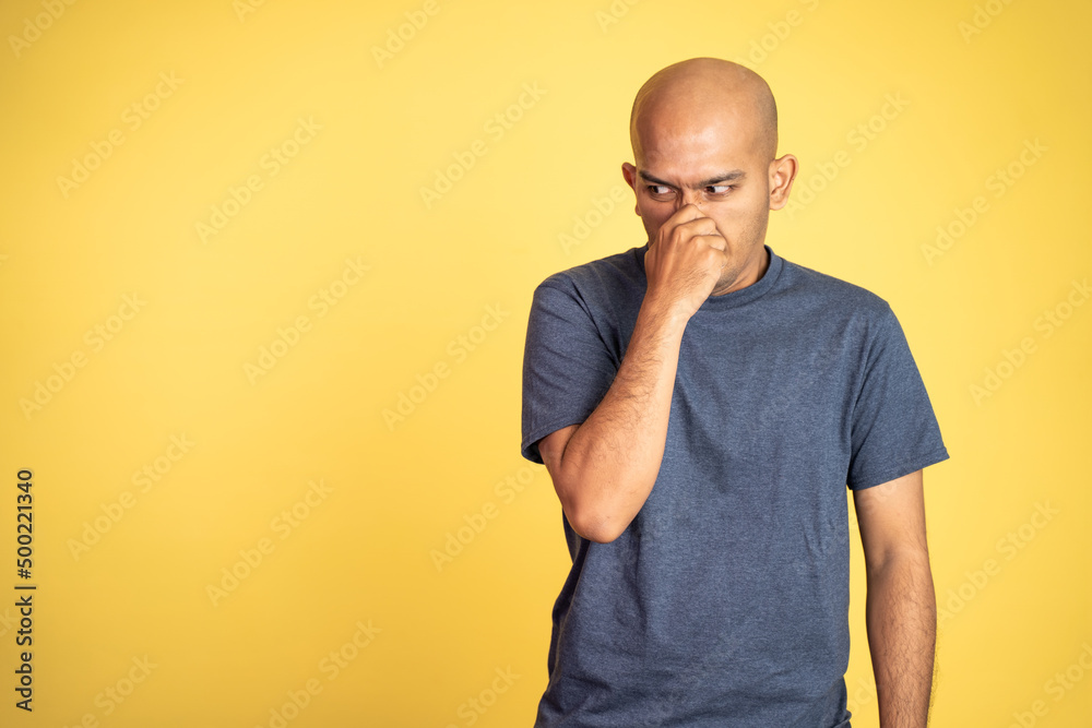 angry asian bald man covering nose with hands on isolated background angry asian bald man covering nose with hands on isolated background