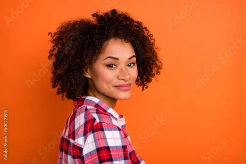 Photo of charming adorable young woman wear plaid shirt smiling isolated orange color background © deagreez