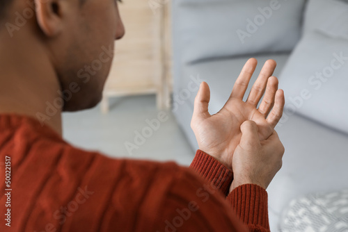 Konstfotografi Man suffering from trigger finger at home, closeup