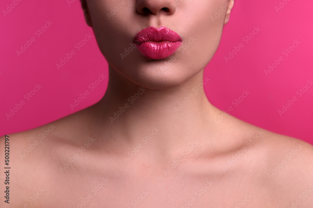 Closeup view of beautiful woman puckering lips for kiss on pink background Closeup view of beautiful woman puckering lips for kiss on pink background