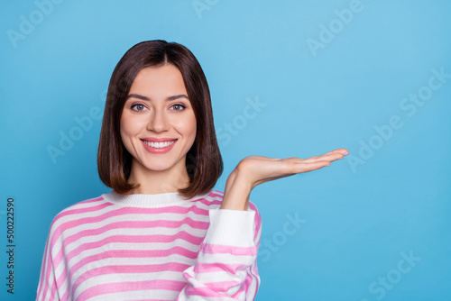 Photo of sweet charming woman wear striped sweater holding arm empty space isolated blue color background