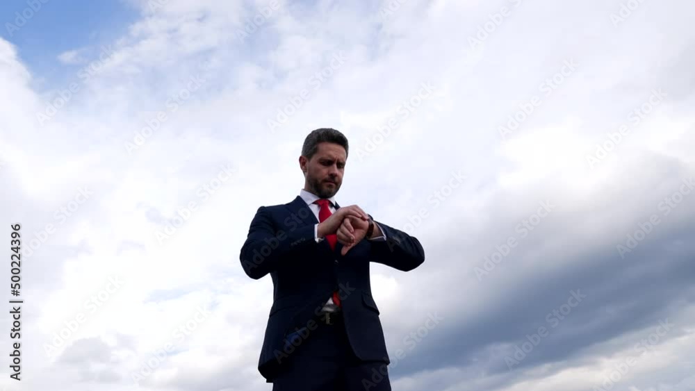 Punctual professional man check watch in cloudy sky, waiting Punctual professional man check watch in cloudy sky, waiting