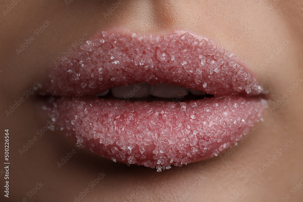 Naklejka premium Young woman with beautiful lips covered in sugar, closeup
