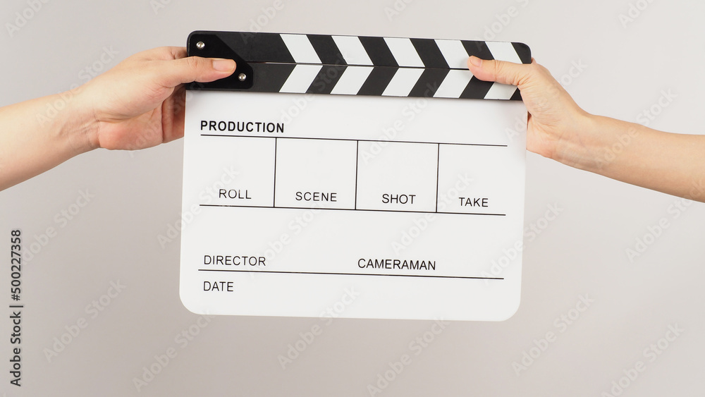 Two hands send and hold white clapper board or movie slate on white background.