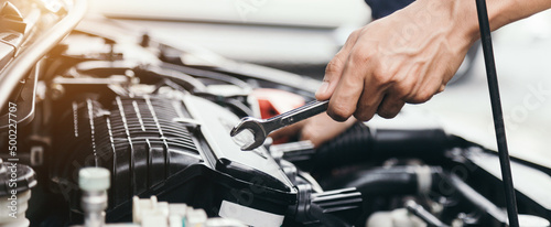 Automobile mechanic repairman hands repairing a car engine automotive workshop with a wrench  car service and maintenance  Repair service.