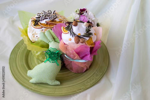 Two Easter cakes and a textile bunny on a green plate