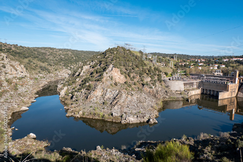 Entre montes e montanhas o rio douro junto à barragem hidroelétrica e a aldeia de Salto de Villalcampo ao fundo em Castilla y León, Espanha photo