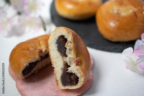 桜の塩漬けを真ん中にのせた二つに割られた美味しそうな桜あんパンのクローズアップ