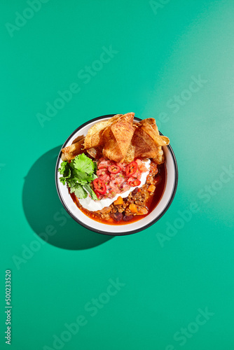 Fotografía Chili con carne on colour background with hard shadow