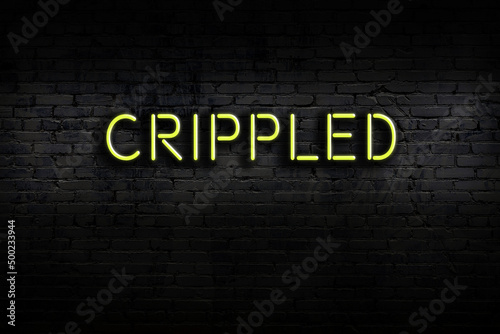 Night view of neon sign on brick wall with inscription crippled Fototapet