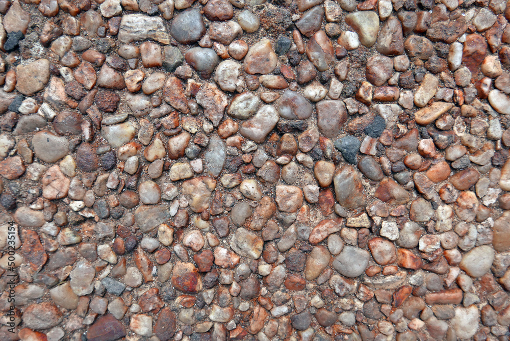 surface with small rounded brown stones with cement, ideal as a texture for a background surface with small rounded brown stones with cement, ideal as a texture for a background