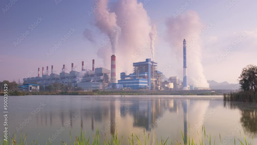Time lapse video 4K motion, Beautiful dawn may be seen. Thailand, Mae Moh coal power plant and lake. The pipe cooling tower emits an industrial white steam, creating a conceptual environ Time lapse video 4K motion, Beautiful dawn may be seen. Thailand, Mae Moh coal power plant and lake. The pipe cooling tower emits an industrial white steam, creating a conceptual environ