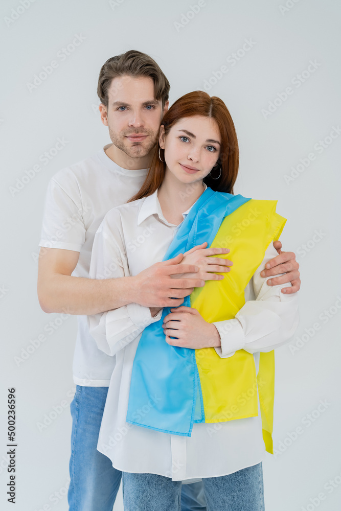 Young couple with ukrainian flag looking at camera isolated on white. Young couple with ukrainian flag looking at camera isolated on white.