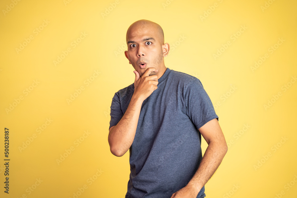 amazed asian bald man with hands holding mouth standing on background isolated amazed asian bald man with hands holding mouth standing on background isolated