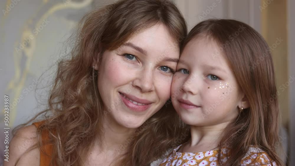 Portrait of lovely family mother and daughter embracing and kissing each other at home. Happy sweet woman with little 6-year-old girl in yellow dresses, family look, sitting on floor. Sweet family Portrait of lovely family mother and daughter embracing and kissing each other at home. Happy sweet woman with little 6-year-old girl in yellow dresses, family look, sitting on floor. Sweet family