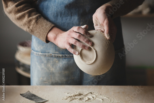 Pottery making studio workshop, hands making ceramic bowl ready for further roasting 