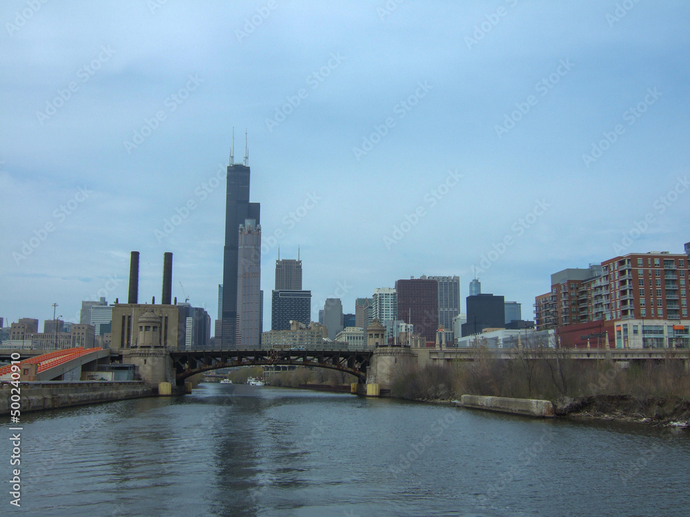 Chicago skyline from Chicago River waterfront under slightly cloudy skies