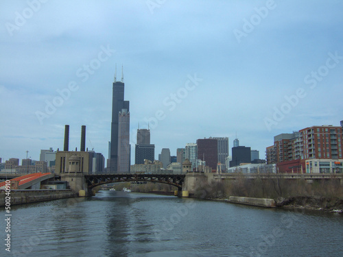 Chicago skyline from Chicago River waterfront under slightly cloudy skies © Luca Schmidt