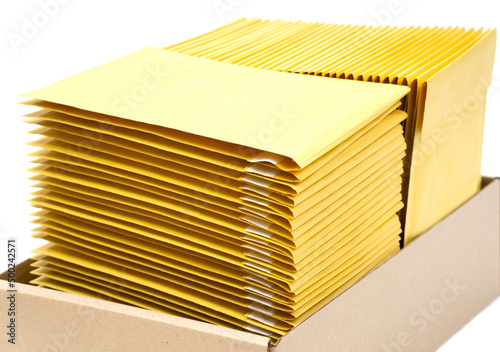 Close-up of yellow mailers in a box on white photo