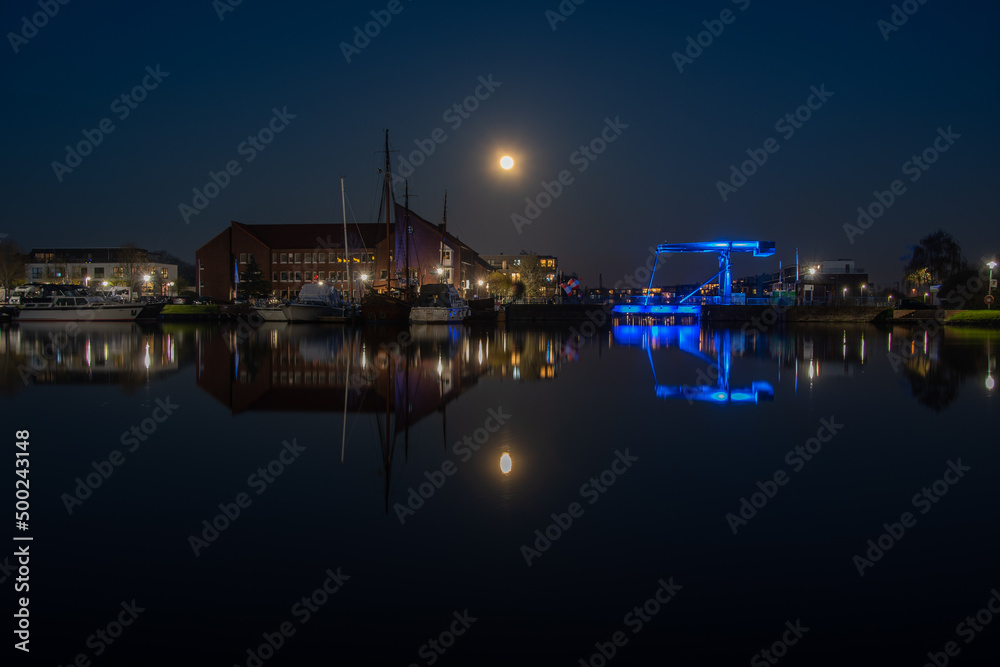The old inland port of Emden with the blue bridge under a full moon
