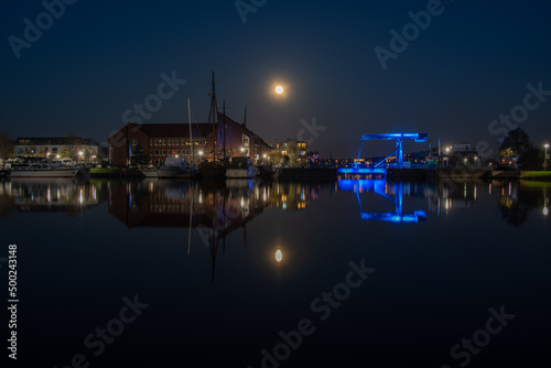 The old inland port of Emden with the blue bridge under a full moon