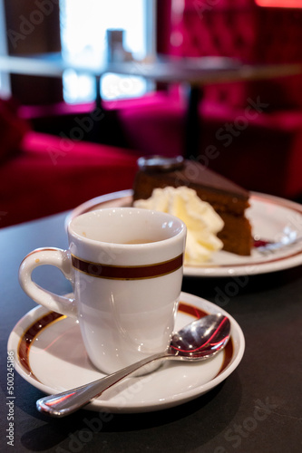Small cup of black espresso coffee served in traditional cafe in Vienna with red interieur  Austria