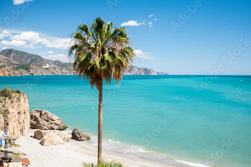 Travel destination  view on sandy beach  blue sea and mountains from Balcon de Europa in small Andalusian town Nerja with white houses and narrow streets on Costa del Sol  Spain